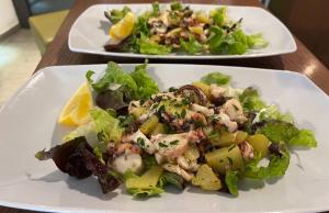 two plates of food with a salad on a table at Hotel Ristorante della posta , cama in Cama