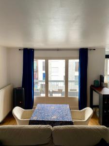 a living room with a table and a couch at Appartement rénové et aux portes de Paris ! in Nanterre