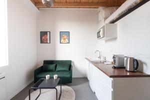una cocina con una silla verde junto a un mostrador en Cabana & Studio Duplex Parilly - Métro 5 minutes, en Bron