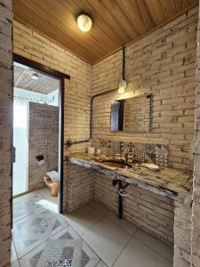 a bathroom with a sink and a wooden wall at Pousada Vale das Flores in Nova Friburgo