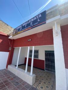 un edificio rojo y blanco con un cartel en él en HOTEL casa VALLENATA en Valledupar