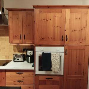 a kitchen with wooden cabinets and a white oven at Angel's home in Dublin