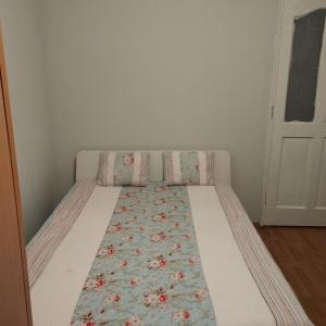 a bed with a floral blanket on it in a room at Angel's home in Dublin