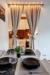 - une table à manger avec des assiettes et des verres à vin dans l'établissement Dream House Belgrade, à Belgrade