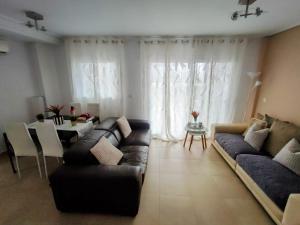 een woonkamer met een bank en een tafel bij Hacienda Riquelme Golf Resort Ground Floor Apartment Sucina Murcia in Murcia