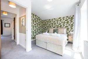 ein Schlafzimmer mit einem Bett und einem Wandbild in der Unterkunft Rest&Recharge at Brookdale House (5 Bedrooms, 15mins to City Centre, Free Parking) in Manchester