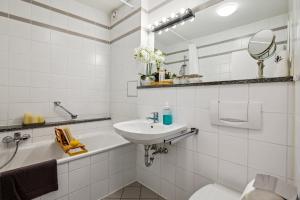 Baño blanco con lavabo y aseo en Comfort Apartment - bis 4 Pers - Neunkirchen City - Parkplatz - Garage - WiFi - Bad - Balkon, en Neunkirchen