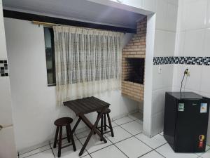 a kitchen with a table and two stools in a room at Arraial Sobradinho in Arraial do Cabo