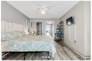 a bedroom with a bed and a ceiling fan at Lifes a beach on Myrtle Beach in Myrtle Beach +26 photos