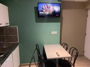 Il comprend une cuisine avec une table et une télévision murale. dans l'établissement Appartement 4 - Hyper centre - 1 à 4 personnes, à Douai
