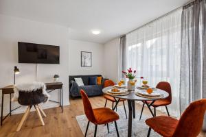 ein Wohnzimmer mit einem Tisch, Stühlen und einem Sofa in der Unterkunft Comfort Apartment - bis 4 Pers - Neunkirchen City - Parkplatz - Garage - WiFi - Bad - Balkon in Neunkirchen