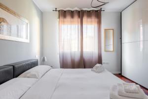 una camera da letto con un grande letto bianco e una finestra di Casa Pibe de oro Bologna Fiera a Bologna