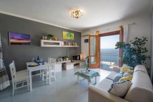 a living room with a couch and a table with a dining room at Casa Sea la Vie in Praiano