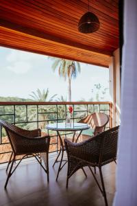 patio con mesa y sillas en el balcón en Fazenda sol nascente, en Pau dʼAlho