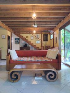 ein Wohnzimmer mit einem roten Sofa und einem Tisch in der Unterkunft Tema'e Beach House in Temae