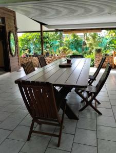 uma mesa de madeira e cadeiras num pátio em Tema'e Beach House em Temae