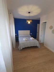 - une chambre dotée d'un lit avec un mur bleu dans l'établissement Casa Elisa 3, à León