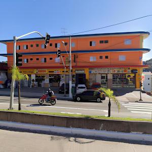 ein orangefarbenes Gebäude mit einer Person auf einem Motorrad in der Unterkunft Hotel Pinheiros in São Paulo