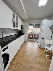 a white kitchen with a sink and a dishwasher at Habitación en Madrid in Madrid