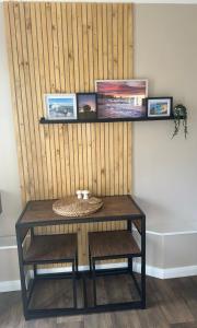 a table with three pictures on a wall at The Cwtch,Self Contained Coastal Annex Freshwater in Freshwater