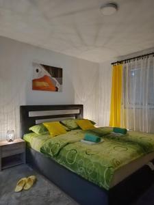 Apartman D في فيشغراد: غرفة نوم بسرير كبير وملاءات صفراء وأخضر
