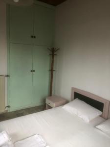 a bedroom with a white bed and a cross on the wall at Barreira Beachfront Rooms 3 in Kalamata