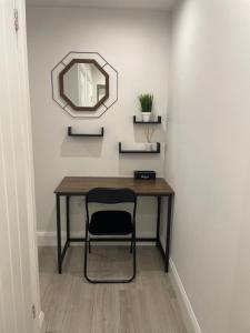 a table with a chair and a mirror on a wall at Blue Madison in Aldershot