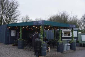 Un hombre de pie en una tienda de campaña con plantas y luces. en Comfy home in Newport, en Newport