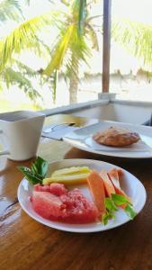 dos platos de comida en una mesa con fruta en Rincón del mar Hotel Boutique los Veleros en San Onofre