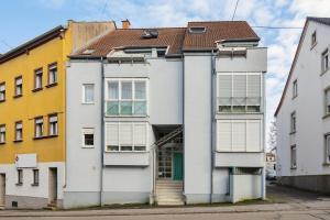 ein weißes Gebäude mit braunem Dach in der Unterkunft Comfort Apartment - bis 4 Pers - Neunkirchen City - Parkplatz - Garage - WiFi - Bad - Balkon in Neunkirchen