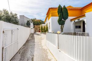 een wit hek voor een huis bij MADA HOUSE's in Sesimbra