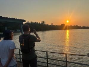 un hombre tomando una foto de la puesta de sol en Bentre Coco Lodge, en Ben Tre
