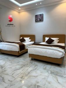 two beds in a hotel room with marble floors at منتجع سمو الوسام Wesam Highness Resort in Taif