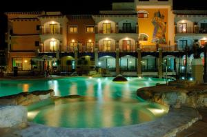 a swimming pool in front of a building at night at Hotel La Laguna Spa & Golf in Torrevieja