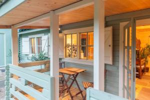 a tiny house with a table on the porch at Family friendly sunny Log Cabin in Wimborne Minster