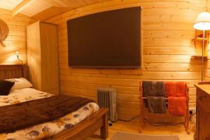 a bedroom with a tv on a wooden wall at Family friendly sunny Log Cabin in Wimborne Minster