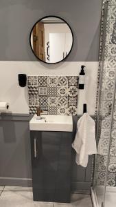 a bathroom with a sink and a mirror at The Cwtch,Self Contained Coastal Annex Freshwater in Freshwater