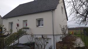 a white house with a window and a fence at Chambre chez l'habitant avec Sdb et WC privatifs in Marnay-sur-Seine