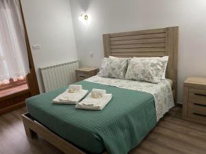 ein Schlafzimmer mit einem Bett mit zwei Handtüchern darauf in der Unterkunft Fraga de Pitões in Pitões das Júnias