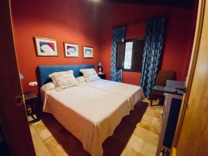 ein Schlafzimmer mit einem Bett in einem roten Zimmer in der Unterkunft LA CHOCITA in Aracena