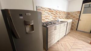 a kitchen with a stainless steel refrigerator and a sink at Acogedor apartamento esquinero, a una cuadra del parque principal in Líbano