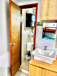 a bathroom with a sink and a toilet and a television at Habitación amplia independiente en Riohacha in Ríohacha