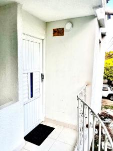 a white door of a house with a sign on it at Habitación amplia independiente en Riohacha in Ríohacha