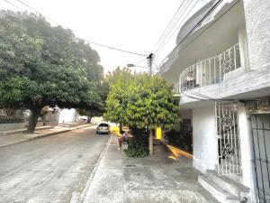 a street with a tree on the side of a building at Habitación amplia independiente en Riohacha in Ríohacha