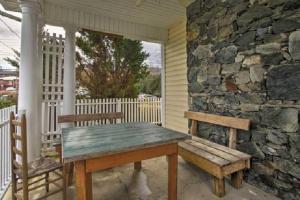 a wooden table and bench on a porch with a stone wall at Downtown Boone ON King Street - 2 Bedroom Home in Boone