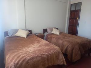 a room with two beds and a couch at HOTEL NOBLEZA in Potosí