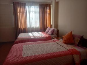 a hotel room with two beds and a window at HOTEL NOBLEZA in Potosí