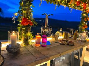 einen Holztisch mit Kerzen und Blumen darauf in der Unterkunft Tan Y Bryn Glamping in Conwy