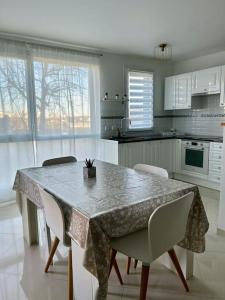 a kitchen with a table with chairs and a tableablish at Appartement 10 mn de Paris et 5 mn du terminus Paris-Bauvais in Saint-Denis
