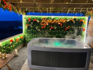 a jacuzzi tub in front of a flower garden at Tan Y Bryn Glamping in Conwy